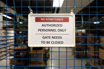 No admittance sign at a closed gate in a warehouse