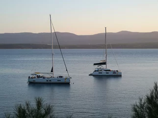 Photo sur Plexiglas Plage de la Corne d'Or, Brac, Croatie Two sailing boats are anchored in the bay at Zlatni Rat. Soft evening light shortly before sunset. The island of Hvar can be seen in the background.