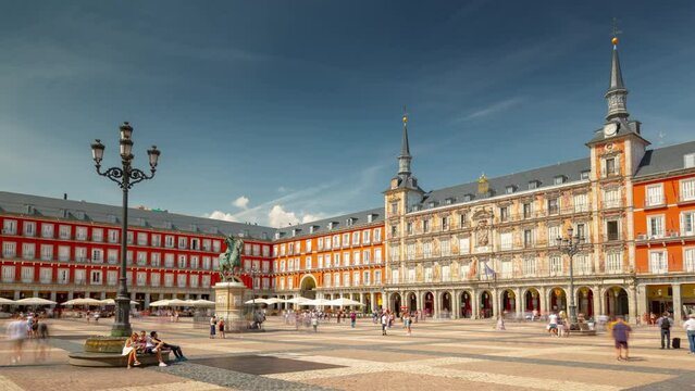 MADRID, SPAIN - FEBRUARY 19, 2024: Timelapse hyperlapse at Mayor plaza in Madrid in a beautiful sunny day with cloudy sky. Famous touristic landmark in old historical city center.