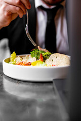 Busy at work. Businessman on business lunch at restaurant sitting at table eating vegetable salad