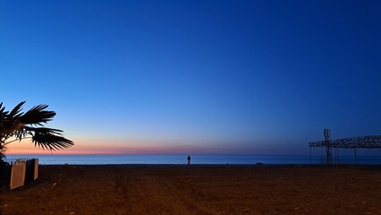 the sun dips below the horizon casting a warm golden glow across tranquil sea.