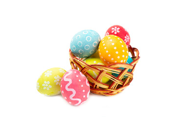 Easter basket filled with colorful eggs isolated on white background. Easter celebration concept. Colorful easter handmade decorated Easter eggs.