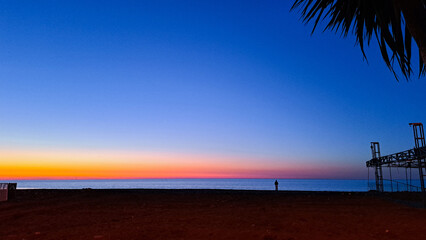 Fototapeta na wymiar the sun dips below the horizon casting a warm golden glow across tranquil sea.