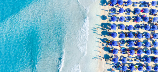 Aerial view on beach, people and umbrellas. Vacation and adventure. Mediterranean Sea. Top view from drone at beach and azure sea. View on the coast from drone. - 745912899