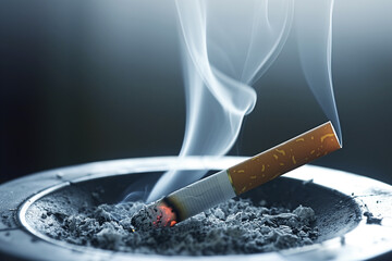 smoldering cigarette in ashtray, smoke rising steadily - obrazy, fototapety, plakaty