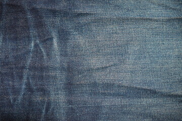 Top view of dark blue jeans fabric with white stains for background and decoration Textile texture...