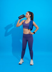 Asian Sporty young woman drinking protein shake isolated on blue background.