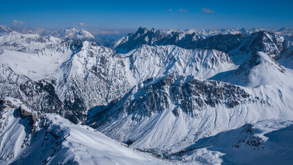 Winter mountain panorama from mountain peak of Namloser Wetterspitze in Tyrol, Austria, sunny blue sky day. - 745923630