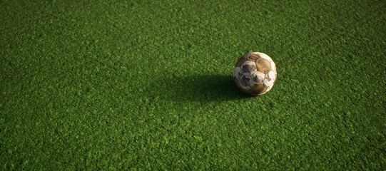 Worn old football on artificial grass. Lit by sunlight.