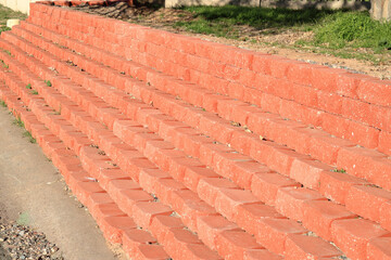 Layers of red bricks neatly stacked to support elevated soil of front yard terrace