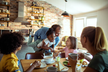 Young mixed family eating together at home
