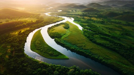 Aerial view of a meandering river through vibrant green wetlands at sunset - obrazy, fototapety, plakaty