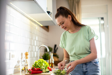 Young woman preparing healthy vegetarian meal in kitchen