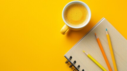 Obraz na płótnie Canvas cup of coffee, notebook and pencils on a yellow background