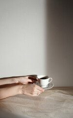 Minimalist aesthetic background with hands holding coffee, copy space, neutral palette