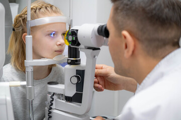 doctor and young patient in eye clinic, girl undergoing an eye test with professional optometrist using advanced diagnostic equipment, pediatric ophthalmology examination