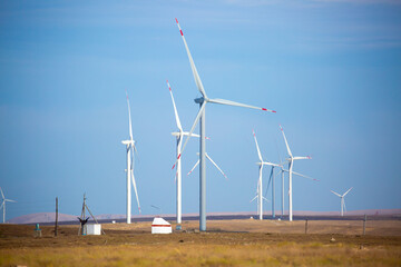 Fleet of power generators in motion. The blades of the wind farm rotate against the sky. The concept of extracting electricity from renewable sources. Wind turbine to generate electricity.