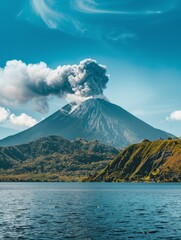 A serene lake reflects the image of a towering volcano mid-eruption, with a plume of ash rising against a clear blue sky. The peaceful water juxtaposes the volatile volcanic activity above. - obrazy, fototapety, plakaty