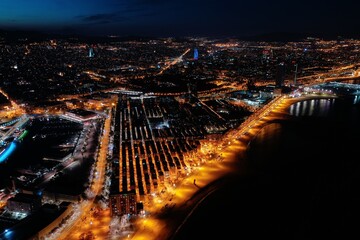 aerial view from la Barceloneta beach and houses at night. Drone view and line of sea