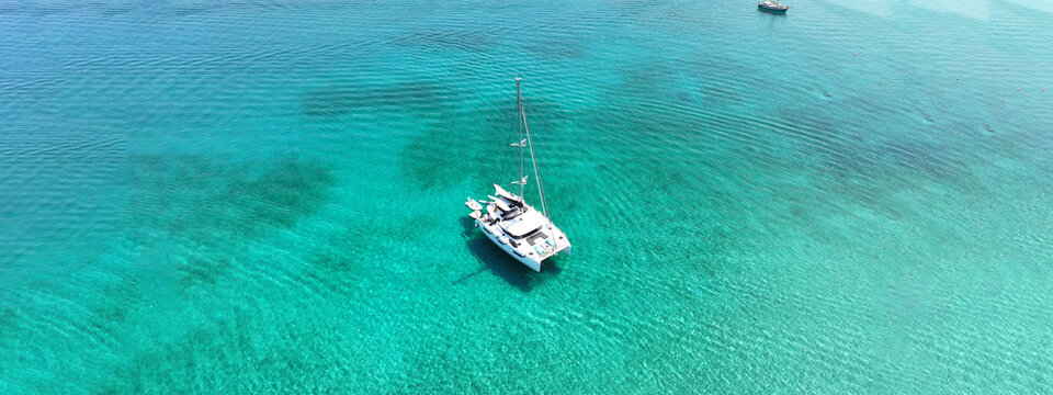 Aerial drone ultra wide photo of beautiful catamaran sail boat sailing in tropical exotic bay with emerald clear sea