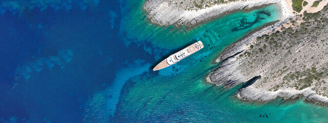 Aerial drone ultra wide photo of inflatable rib power boat anchored in tropical exotic bay with emerald sea and caves