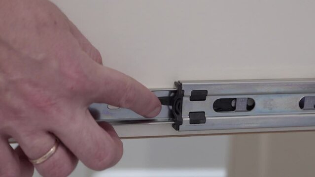 close up of drawer sliding skids, Close up of carpenter hands installing  drawer on sliding skids 