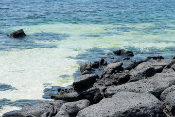 The beach of black rocks at the island's seaside