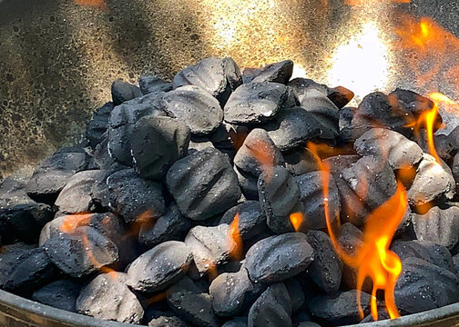 Charcoal briquettes on fire in the family grill