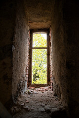 Old window in an abandoned ruined building overlooking the park.