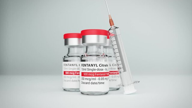 Three vials of the Fentanyl drug (own label design) used as an analgesic but also source of the opioid crisis. A syringe leaning against the frontmost vial. Selective focus - zooming out