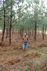 Portrait of young man standing with fur jacket in forest