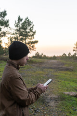 Caucasian man in nature looking at his phone