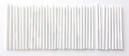 A cluster of white biodegradable eco-friendly paper drinking straws arranged neatly on a tabletop surface. The straws are resting still and untouched. - obrazy, fototapety, plakaty