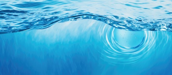 Obraz premium A blue ocean with a wave rising out of the water, creating a dynamic and powerful scene. The wave is moving towards the shore, displaying the force of nature in action.