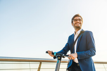 Cropped image of young business man in suit riding electric scooter. Handsome manager ceo...