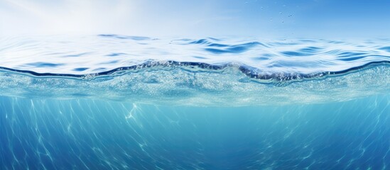 This wide panorama captures the serene blue water of the ocean from an underwater perspective, showing the sandy sea bottom and isolated environment. - obrazy, fototapety, plakaty