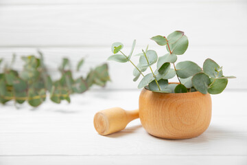 Eucalyptus leaves and mortar on a wooden background.Spa concept.Ingredients for alternative...