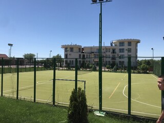 Green soccer field with hotel in the background