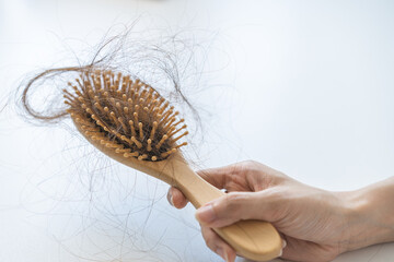 Problem hair, stressed beautiful asian young woman, girl in bathrobe hand holding comb show her hairbrush with hair loss in brush after brushing fall out at home. Health care, beauty with treatment.