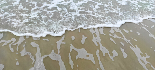 Beautiful soft sea waves with foam on the beach