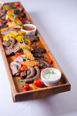 Fototapeta na wymiar Rustic wooden platter with assorted meats and vegetables