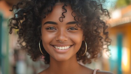 Engaging portrait of a cheerful young lady with curly hair smiling brightly in an urban setting