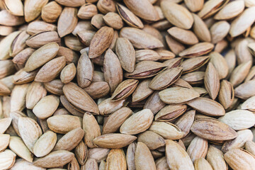 Heap of unpeeled almonds in shells - natural organic nut background