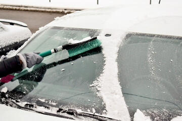 cleaning of the snow from the windshield of a car