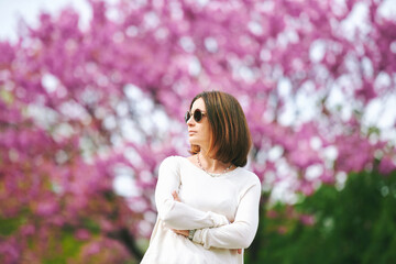 Spring portrait of pretty mature woman posing with lilac flowers on background - 745993686