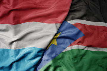 Obraz premium big waving national colorful flag of south sudan and national flag of luxembourg .