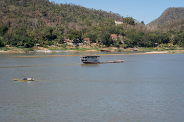 Obraz premium Laotian wooden boats on the Mekong River in Luang Prabang in Laos Southeast Asia