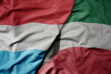 big waving national colorful flag of kuwait and national flag of luxembourg .
