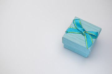 top view of a small gift box with a blue and gold bow on a white background gifts birthdays.