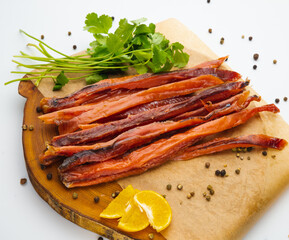 Sliced smoked salmon belly with fresh parsley. Isolated over white background